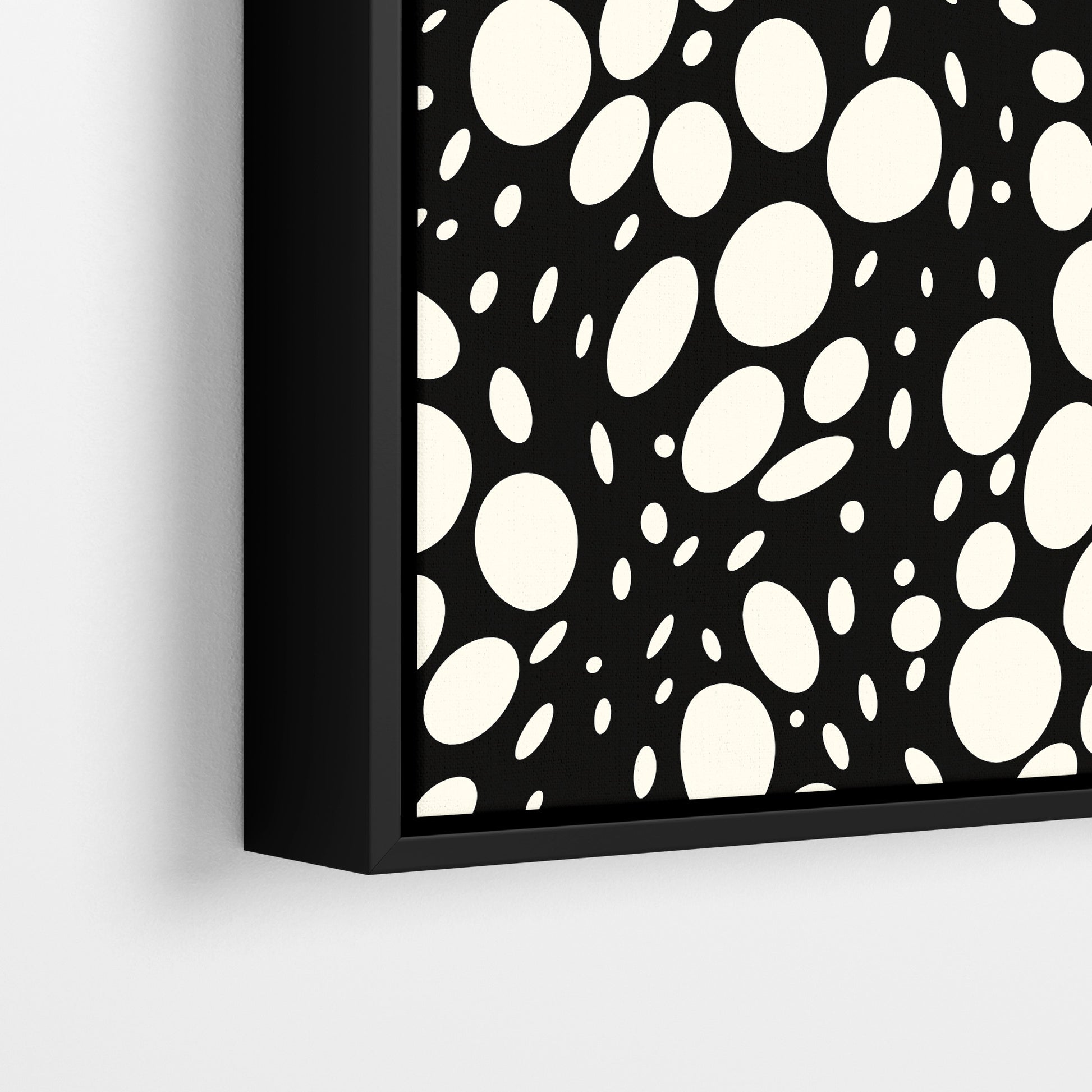Close-up detail of Spots black framed abstract print - hundreds of varied-size white oval shapes creating texture on black background