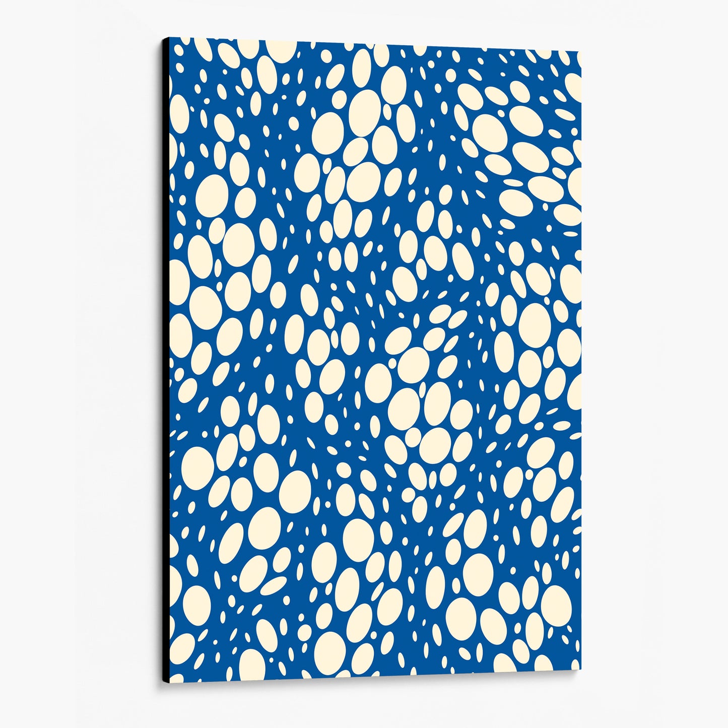 Spots Blue abstract wall art angled view showing an unframed canvas with dynamic organic polka dot design with scattered white spots