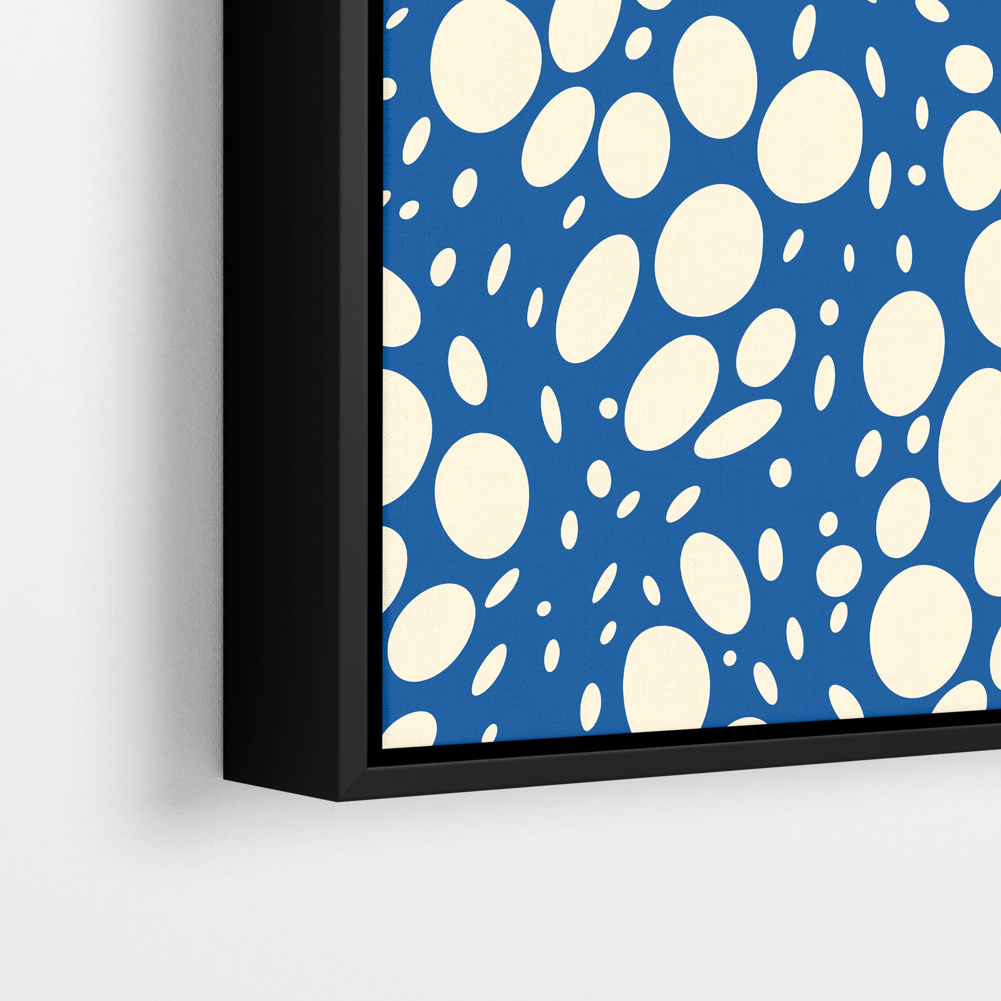Close-up detail of Spots Blue framed abstract print - hundreds of varied-size white oval shapes creating movement on blue background
