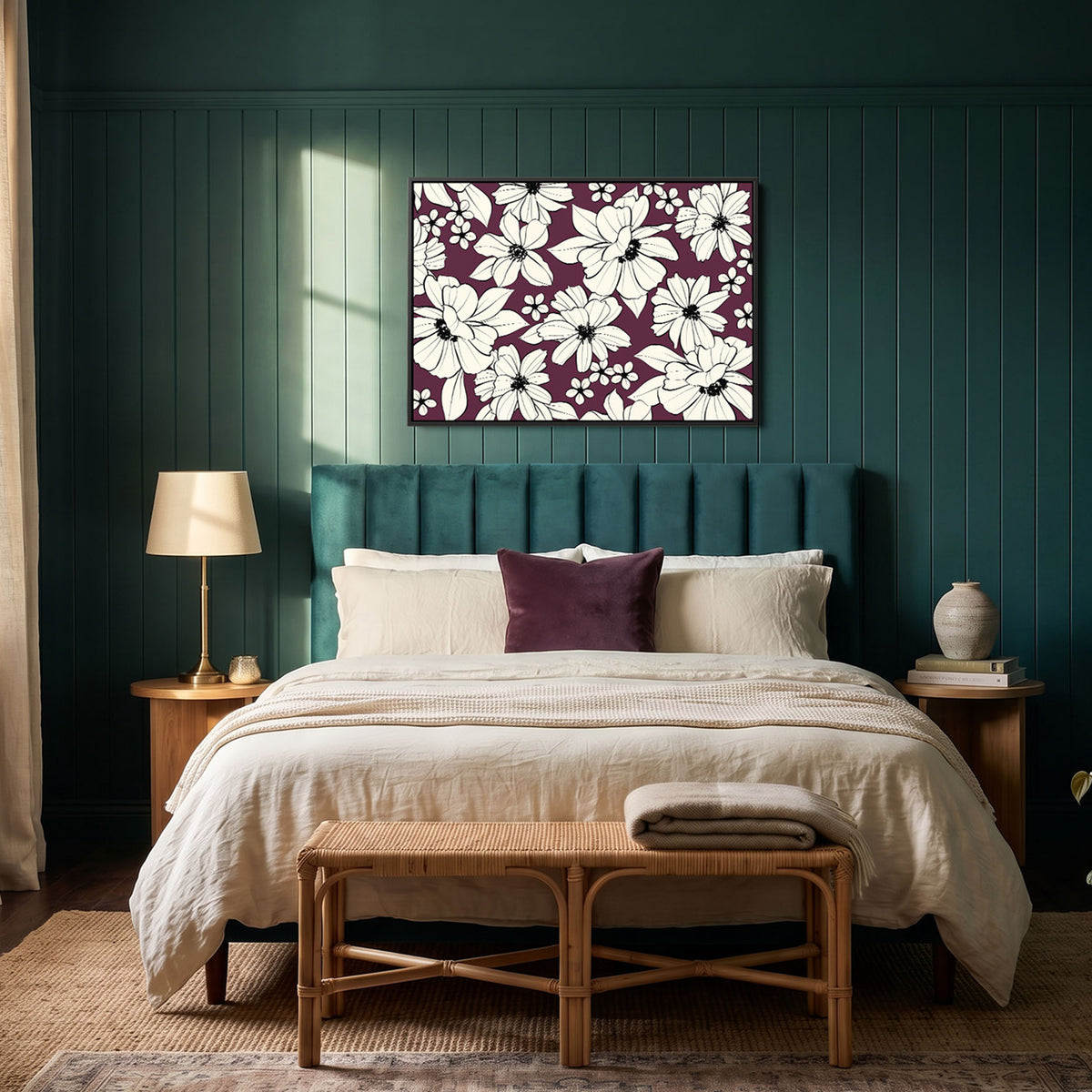 Florian Aubergine black framed floral wall art print with white flowers on a deep purple background hangs above a bed in a styled bedroom with dark teal panelled walls, a green headboard, beige bedding, and a bamboo bench.